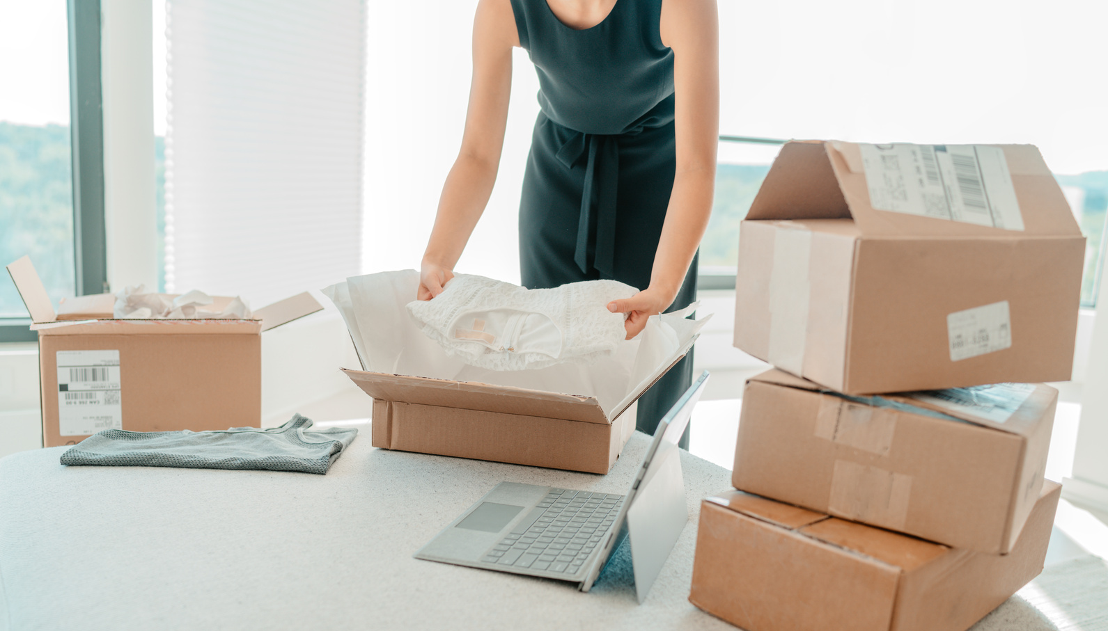Selling Clothing from Home. Small Business Entrepreneur Woman Packing Dress Clothes in Mailing Box for Shipping from Online Store